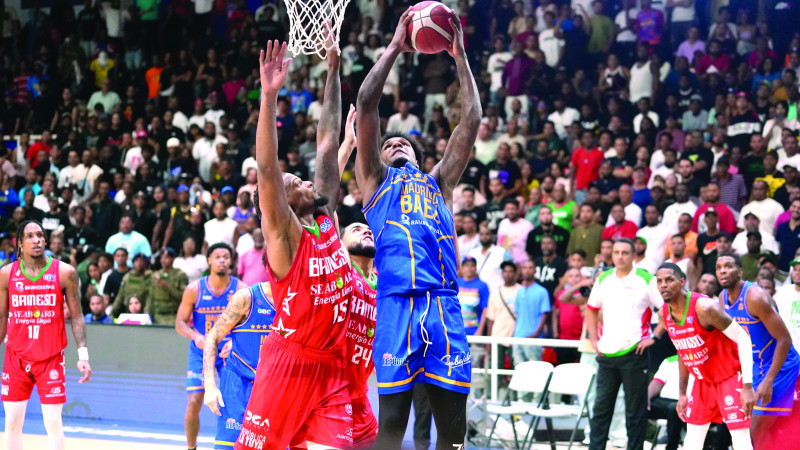 Luismal Ferreiras, del Mauricio Báez, y Miguel Simón, de Bameso, disputan un rebote en el sexto partido de la serie final del torneo de baloncesto superior distrital.