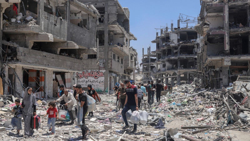 Palestinos en medio de una destrucción por bombardeos israelíes.