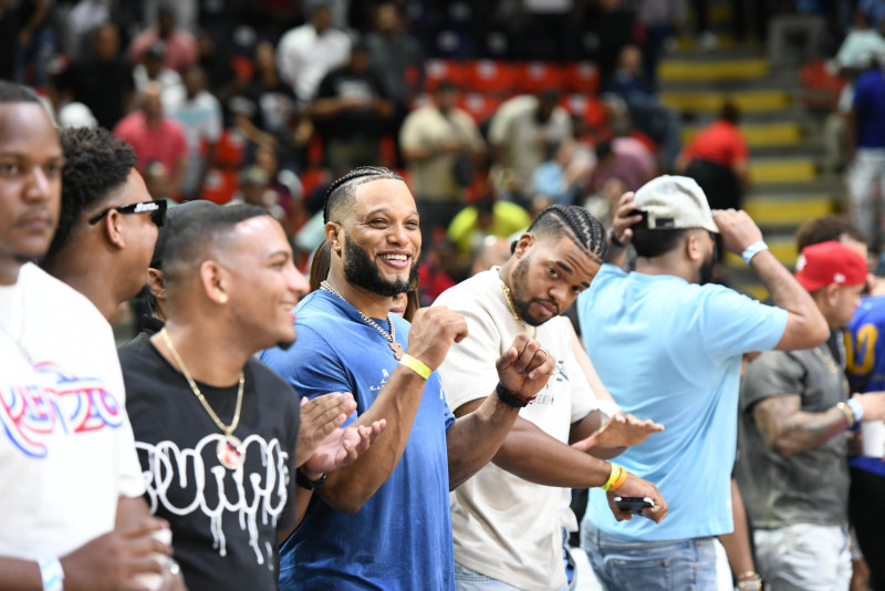 Los pelotero Robinson y Gregory Canó en el área VIP del Pabellón de Voleibol, aplauden una canasta del Mauricio Báez .