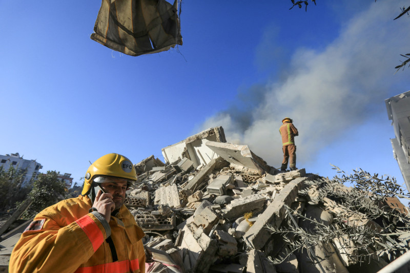 Los rescatistas buscan entre los escombros de un edificio destruido tras un ataque aéreo israelí