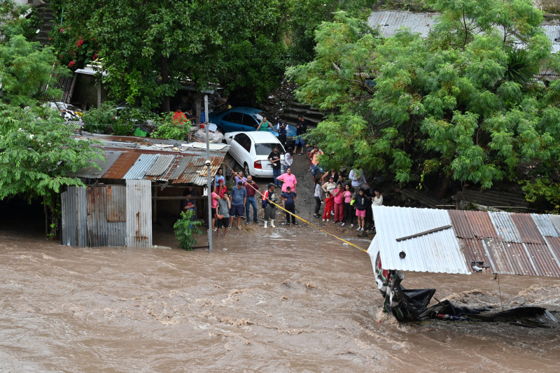 Personas observan el desbordamiento del río Choluteca en Tegucigalpa