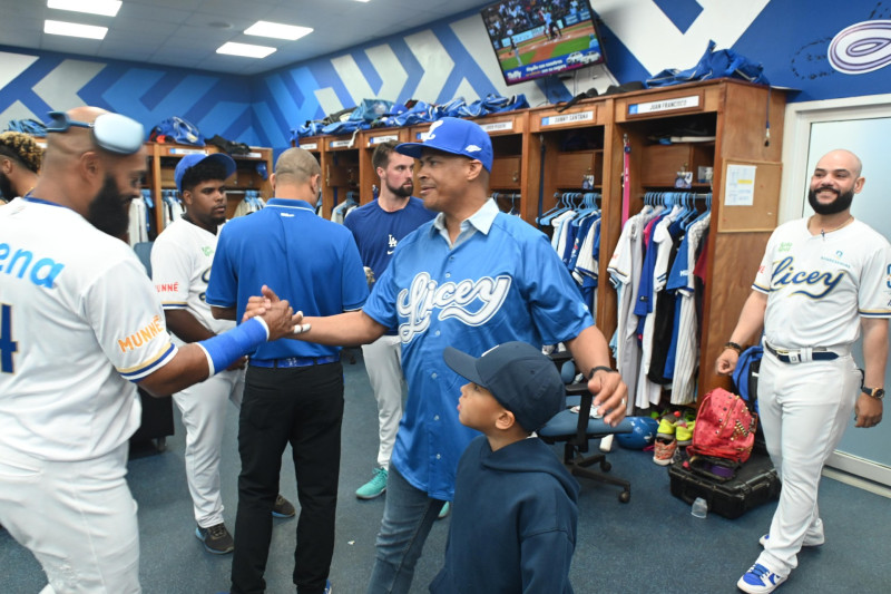 El ex campeón olímpico y mundial mientras saludaba al capitán del Licey, Emilio Bonifacio en el camerino azul.