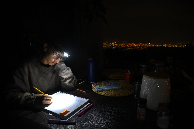 Una estudiante usa un faro para hacer su tarea durante un apagón en Quito, Ecuador, el 13 de noviembre de 2024.