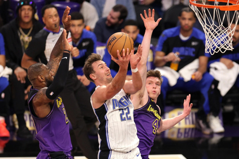 Franz Wagner, de los Magic, supera la defensa de LeBron James y Dalton Knecht, en una acción ofensivo en el partido del jueves en el baloncesto de la NBA.