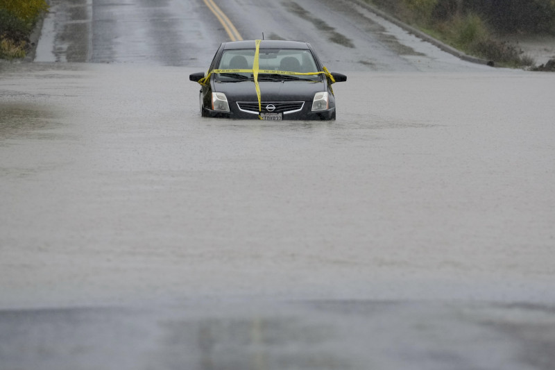 Un automóvil queda varado en una carretera inundada