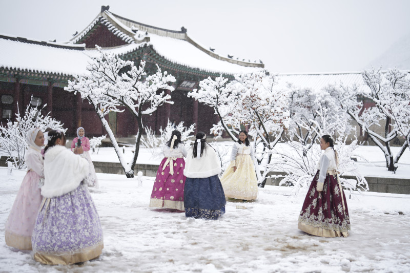 Los visitantes disfrutan de la nieve en el Palacio Gyeongbok