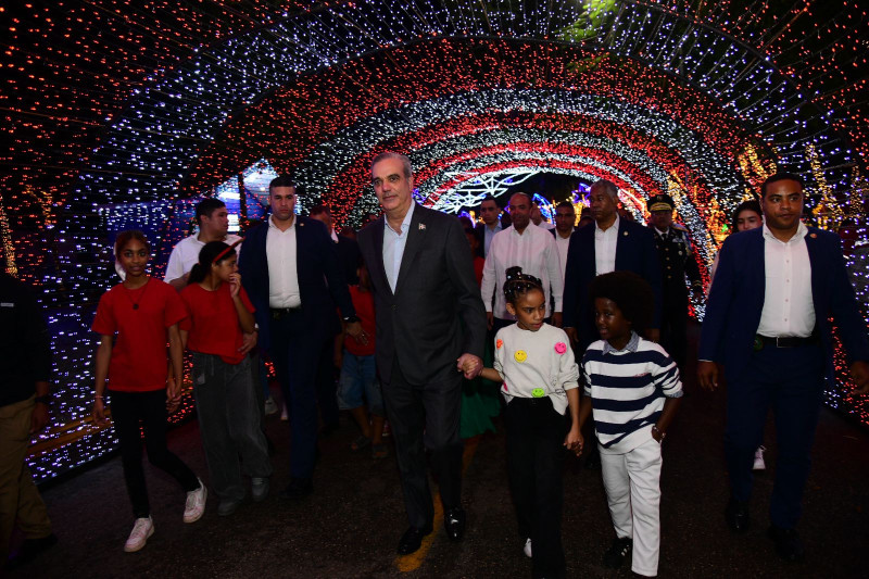 El presidente Luis Abinader recorre Villa Navidad con niños a su alrededor.