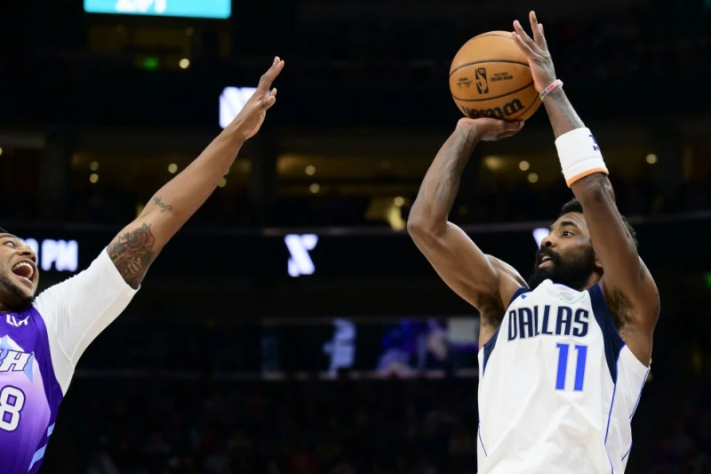 El escolta de los Mavericks de Dallas, Kyrie Irving (11), busca disparar por encima del alero del Jazz de Utah, Brice Sensabaugh, a la izquierda, durante la primera mitad del  partido.