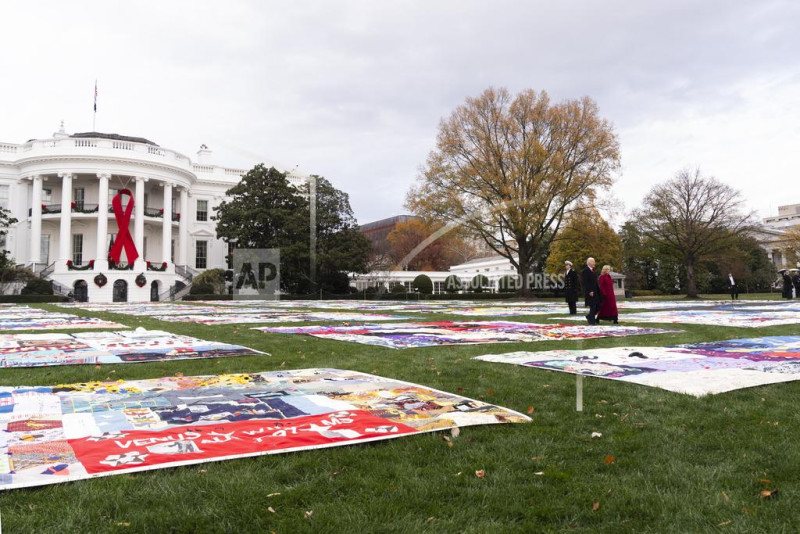 El presidente Joe Biden y la primera dama Jill Biden caminan hacia edredones para conmemorar el Día Mundial de la Lucha contra el Sida, el domingo 1 de diciembre de 2024, en Washington.