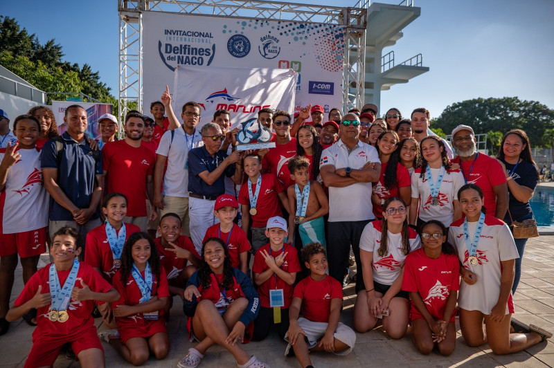 Los ganadores de los Marlins de Arroyo Hondo levantan con orgullo el trofeo de campeones del XLI Invitacional Internacional de Natación Delfines del Naco 2024.