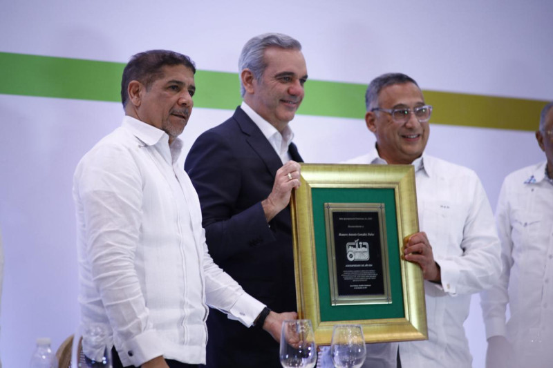 El presidente Luis Abinader y el ministro de Agricultura, Limber Cruz, le entrega reconocimiento a Homero González Duluc.