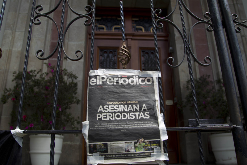 Un ejemplar del periódico El Periódico de Guatemala que dice "Periodistas asesinados" cuelga en la puerta de la Casa Presidencial durante una protesta para exigir una investigación sobre el asesinato de dos periodistas, el 11 de marzo de 2015.