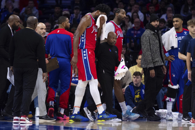 Joel Embiid se coloca una toalla en la cara luego de ser golpeado luchando un rebote.