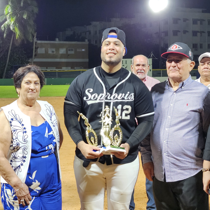 Jorge Bass con sus trofeos de Jugador Más Valioso, líder de jonrones y carreras impulsadas del softbol 2024 de Soprovis, flanqueado por doña Elpidia Dumé de Pimentel y Manuel (Manolo) Troncoso.