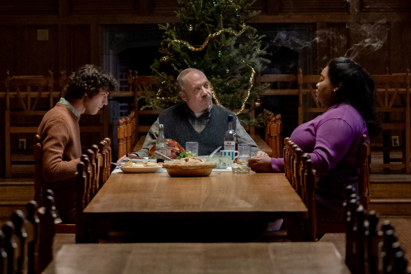 En "The Holdovers" (2023), Paul Giamatti, Dominic Sessa y Da Vine Joy Randolph interpretan a tres personajes que pasan la Navidad aislados, lejos de sus familias. En un gesto de solidaridad y compañía, deciden celebrar una íntima cena de Nochebuena, rodeados de un improvisado árbol de Navidad, demostrando que, incluso en la soledad, el espíritu navideño puede encontrar su lugar. Seacia Pavao/Focus Features