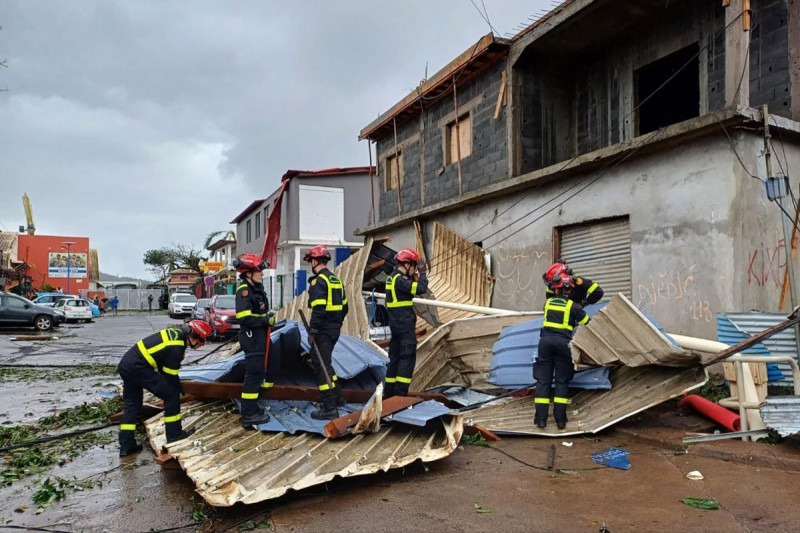 Esta fotografía difundida por la Securité Civile el 15 de diciembre de 2024 y tomada en un lugar no revelado en el territorio francés del océano Índico de Mayotte muestra a miembros de la Seguridad Civil francesa limpiando escombros después de que el ciclón Chido azotara el archipiélago