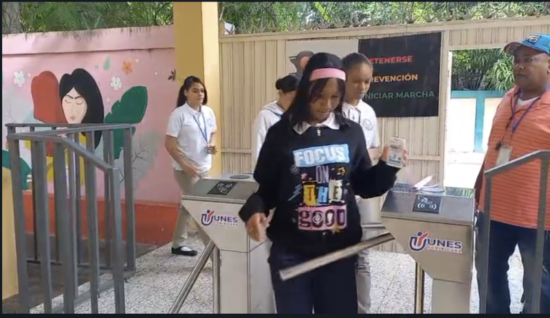 Estudiantes ingresan al politécnico por un pasímetro al “ponchar” sus carnets de identificación.