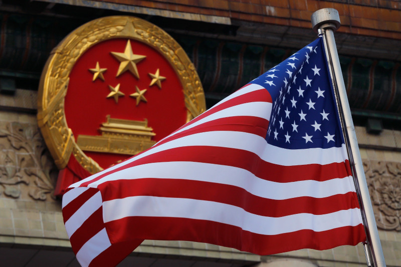 Una bandera estadounidense ondea cerca del emblema nacional de China, fuera del Gran Salón del Pueblo, en Beijing, el 9 de noviembre de 2017.