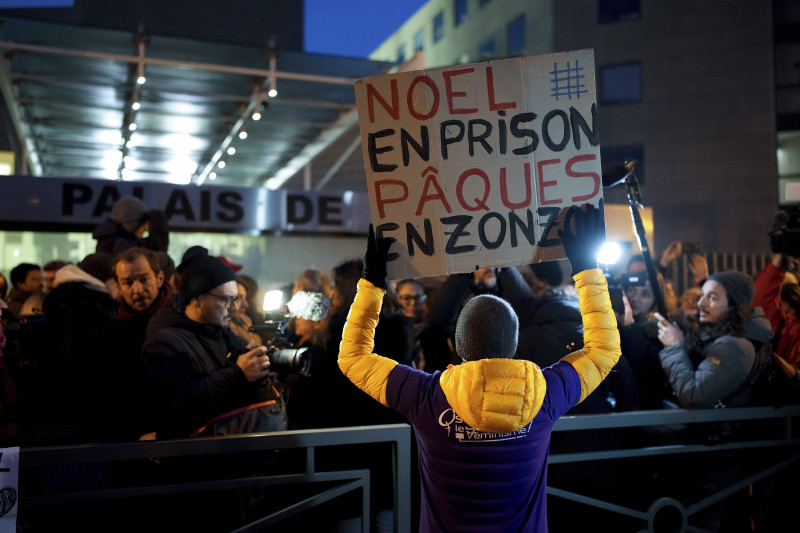 Un hombre con un cartel que dice "Navidad en prisión, Pascua en la cárcel"