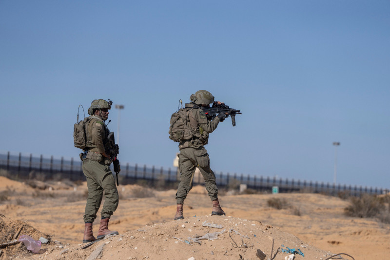 Soldados israelíes apuntan con un arma al montar guardia en el laso palestino del cruce fronterizo de Kerem Shalom durante un recorrido de periodistas por el área de la Franja de Gaza, ayer.