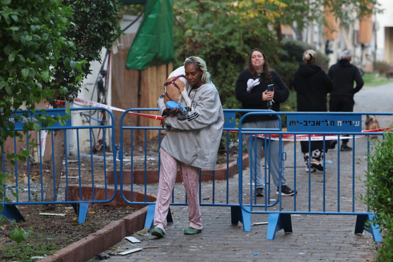 La gente evacúa su casa en Tel Aviv temprano el 21 de diciembre de 2024, después de que un proyectil disparado desde Yemen cayera cerca de su edificio.