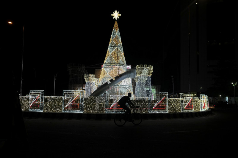 Un hombre pasea en bicicleta entre adornos navideños en una calle de Lagos, Nigeria,