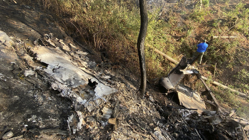 Esta fotografía publicada por Protección Civil del estado de Jalisco muestra a un hombre mirando el lugar donde se estrelló un avión Cessna 207 en Santa María del Oro, estado de Jalisco, México, el 22 de diciembre de 2024.