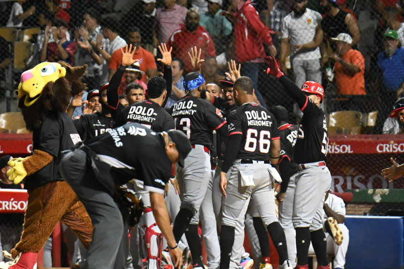 Jugadores del Escogido celebran luego de anotar dos carreras en el octavo inning.