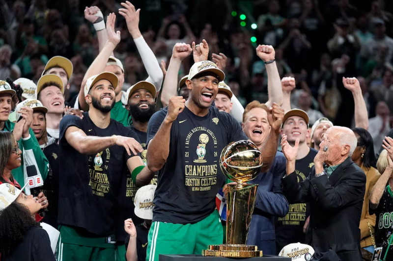 El pívot dominicano de los Boston Celtics Al Horford, en el centro, celebran con sus compañeros de equipo el título de la NBA delante del trofeo Larry O'Brien.