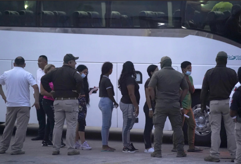 Varios migrantes hacen fila para abordar un bus después de ser deportados de Estados Unidos, de regreso a Matamoros, México, el 11 de mayo de 2023.