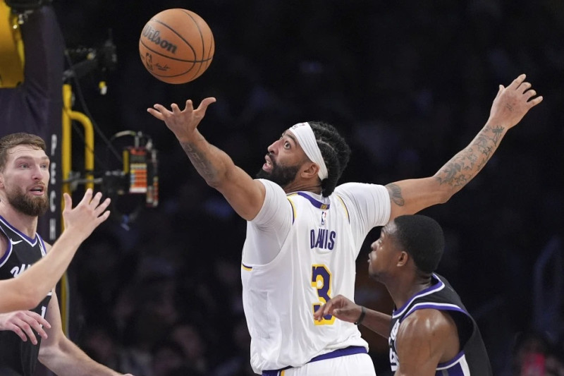 Anthony Davis, alero de los Lakers de Los Ángeles, busca hacerse de un balón perdido entre Domantas Sabonis y De’Aaron Fox, de los Kings de Sacramento.