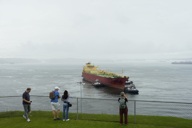 Turistas observan al carguero panameño G. Arete navegando por las esclusas de Agua Clara del Canal de Panamá en la ciudad de Colón, Panamá, el 28 de diciembre de 2024. - El 31 de diciembre de 2024, Panamá celebrará el 25 aniversario de la soberanía sobre el Canal.