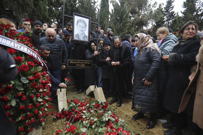 La gente llora ante la tumba de la azafata Hokume Aliyeva durante el funeral de los miembros de la tripulación del Embraer 190 accidente aéreo mortal en Kazajstán esta semana, en el Il Callejón de Honor en Bakú, Azerbaiyán.