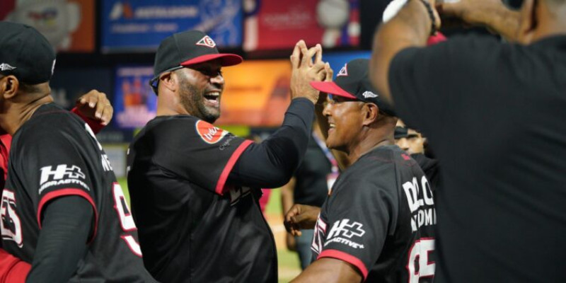 Albert Pujols celebra la victoria de los Leones junto a sus cuerpo de coaches la noche del sábado.