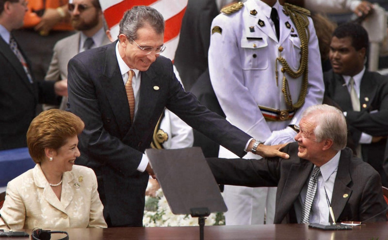 La presidenta panameña Mireya Moscoso observa mientras su homólogo mexicano Ernesto Zedillo felicita a Jimmy Carter tras transferencia del Canal