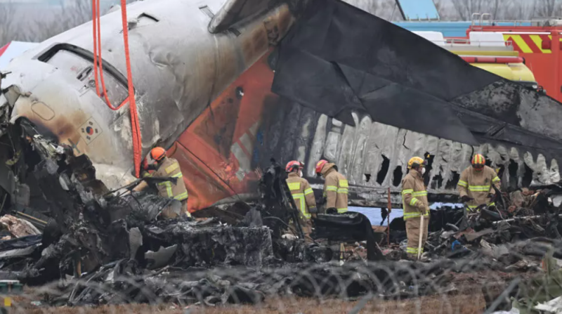 Bomberos y equipos de rescate trabajan entre los restos del avión Boeing 737 de la compañía de Jeju Air siniestrado en el aeropuerto de Muan, el 30 de diciembre de 2024 en esa ciudad al suroeste de Corea del Sur.