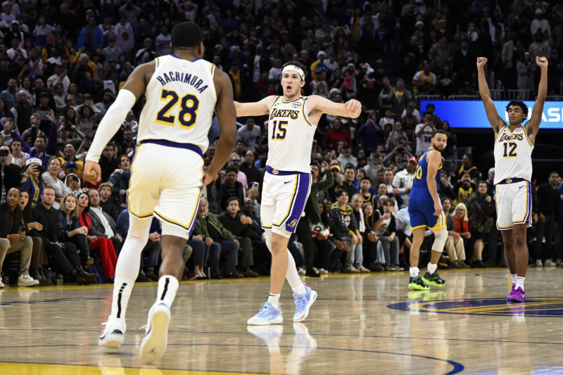 Austin Reaves (15), base de los Lakers, festeja con sus compañeros Rui Hachimura (28) y Max Christie, tras asegurar el triunfo sobre Golden State, el 25 de diciembre.