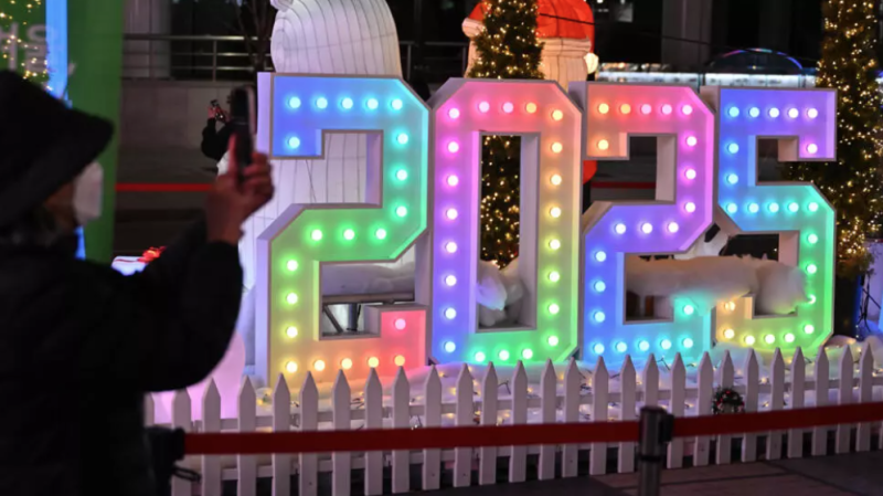 Una mujer toma una foto de un cartel luminoso de 2025 antes de las celebraciones de Año Nuevo en Corea del Sur, el 31 de diciembre de 2024 en Seúl.