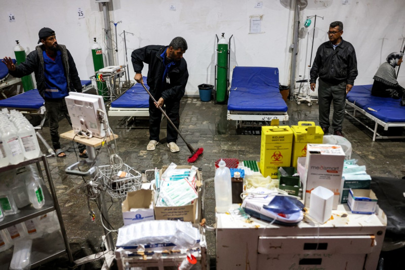 Hombres limpian el agua de lluvia que inundó el anexo de la tienda médica del Complejo Médico Nasser en Khan Yunis, en el sur de la Franja de Gaza, debido a una tormenta, el 31 de diciembre de 2024