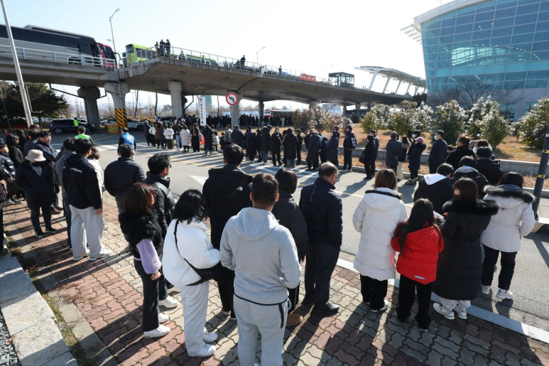 Dolientes esperan a rendir homenaje a las víctimas de un accidente aéreo en un altar de recuerdo en el Aeropuerto Internacional de Muan, en Muan, Corea del Sur, el miércoles 1 de enero de 2025. Kim Sun-woong/AP