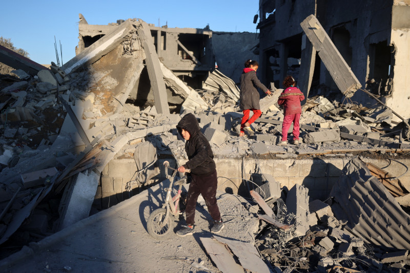 Un niño palestino empuja una bicicleta en medio de la destrucción causada por un ataque israelí en el campo de refugiados de Al-Maghazi, en el centro de la Franja de Gaza, el 3 de enero de 2025, mientras continúa la guerra entre Israel y el movimiento Hamás.