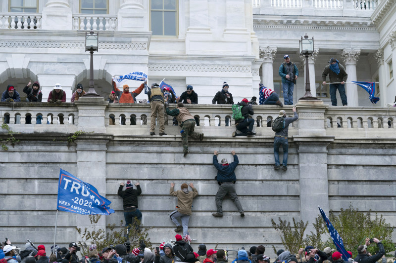 Partidarios del presidente Donald Trump trepan el muro oeste del Capitolio de Estados Unidos