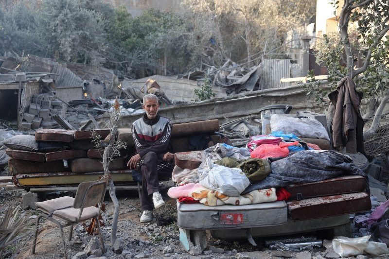 Un hombre se sienta junto a los escombros de sus pertenencias, tras un ataque israelí en Bureij, Franja de Gaza, ayer.