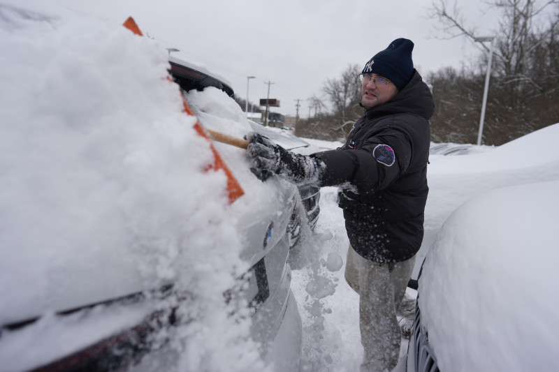 Cary Fallath, técnico de la tienda BMW, limpia la nieve