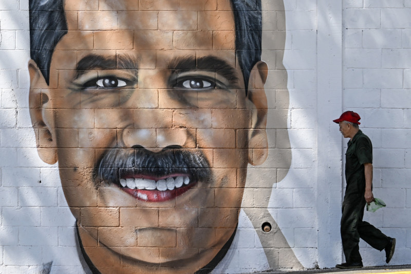 Un hombre camina frente a un grafiti con la imagen del presidente venezolano Nicolás Maduro en Caracas el 8 de enero de 2025.