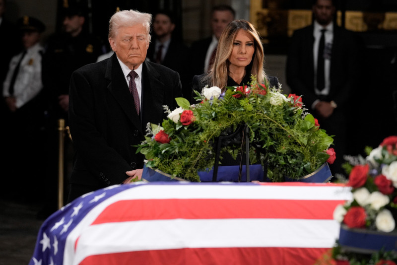 El presidente electo Donald Trump y su esposa, Melania Trump, frente al féretro del expresidente Jimmy Carter durante su funeral en el Capitolio federal, ayer.