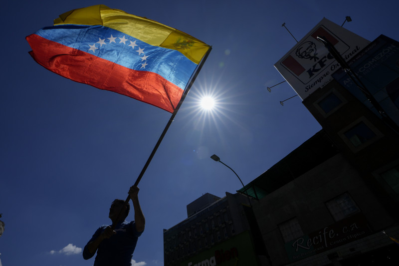 Un hombre ondea una bandera durante una protesta de opositores del presidente venezolano Nicolás Maduro el día antes de su toma de posesión para un tercer mandato en Caracas, Venezuela, el jueves 9 de enero de 2025. (AP Foto/Matías Delacroix)