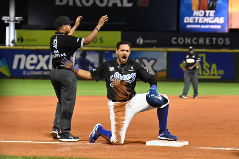 Cristhian Adames celebra con el dogaut del Licey luego de conectar triple.