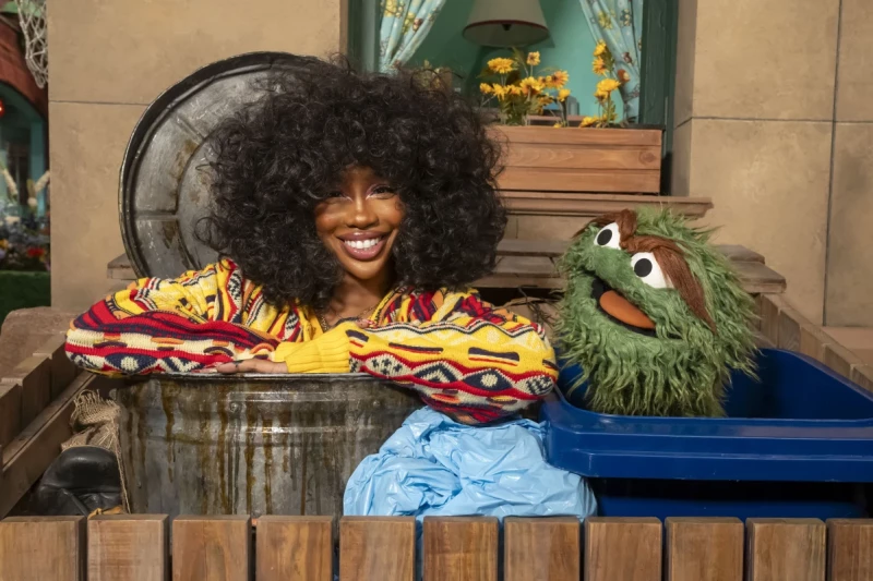 Esta imagen publicada por Sesame Workshop muestra a la cantante SZA, a la izquierda, con el personaje muppet Oscar the Grouch en el set de "Sesame Street".