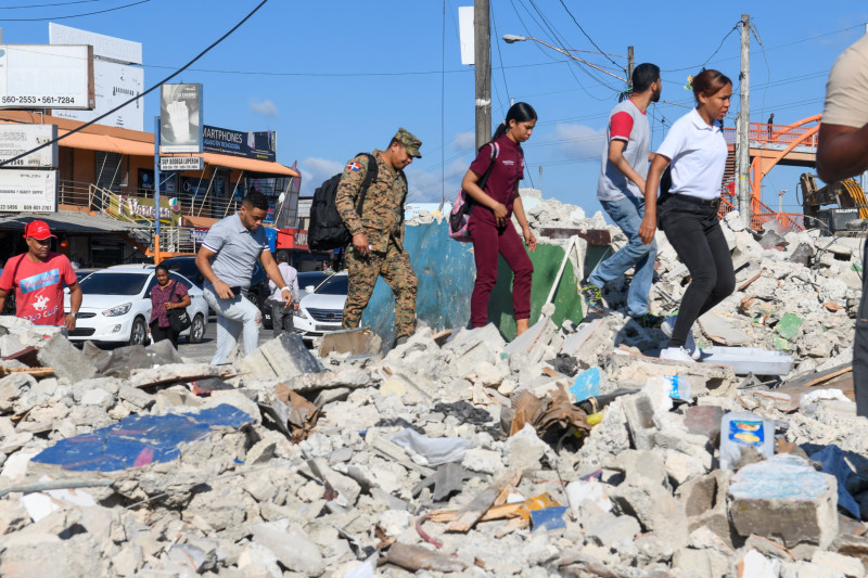 Comerciantes caminando sobre los escombros